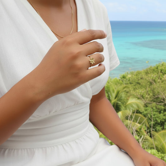 Femme portant une bague dorée en acier inoxydable 316L ornée d’une petite fleur en acier.
