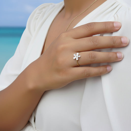 Femme portant une bague dorée, ajustable, en acier inoxydable, ornée d'une petite fleur.