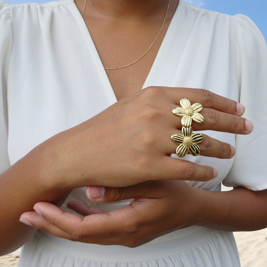 Femme portant des bagues fleur rayées noir et blanc en acier inoxydable doré.