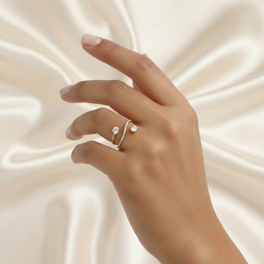 Main de femme portant une bague anneau dorée en acier inoxydable 316L avec zircons blancs.