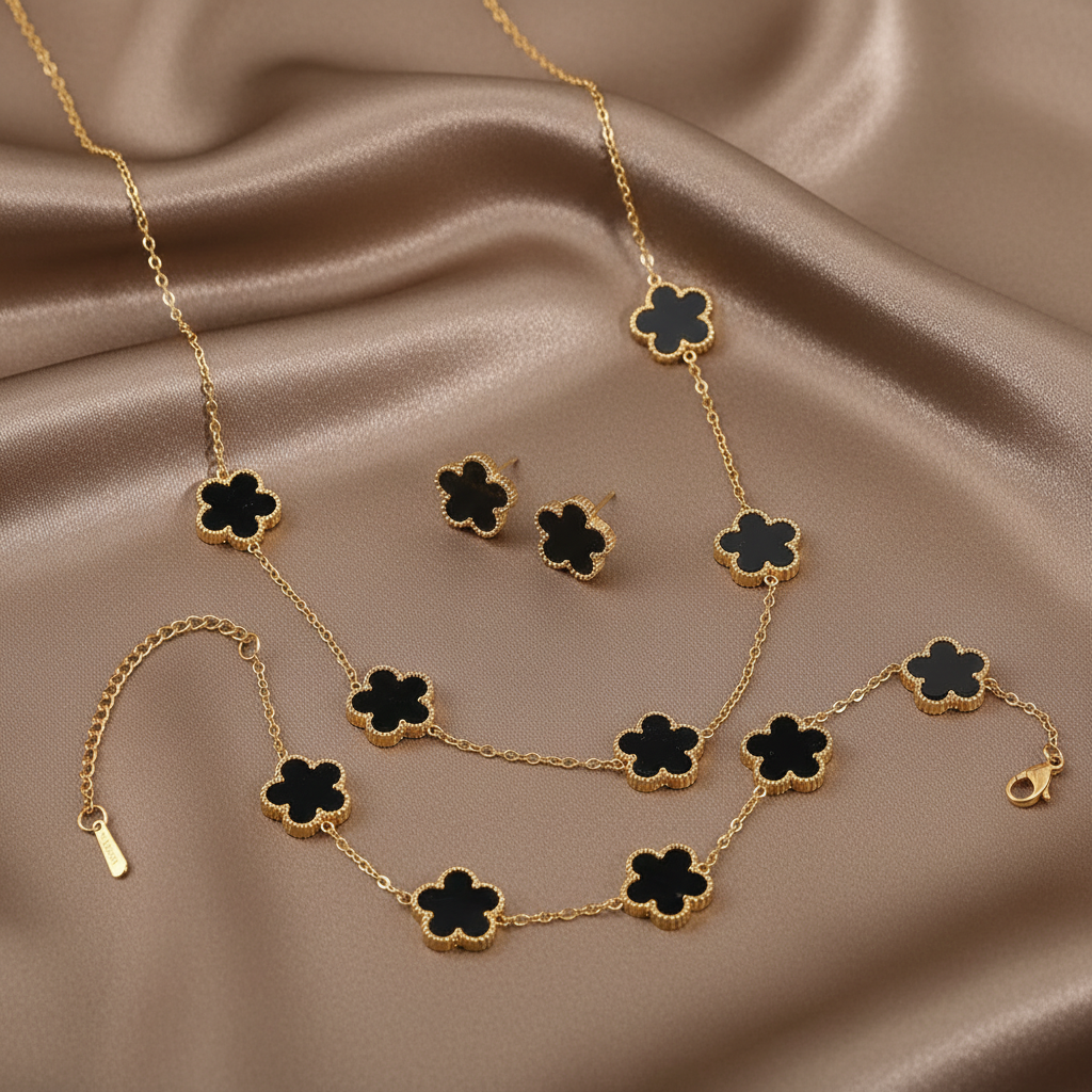 Parure comprenant bracelet, collier et boucles en acier inoxydable 316L doré ornés de petites fleurs en pierre naturelle noire recto verso.