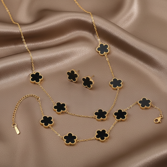 Parure comprenant bracelet, collier et boucles en acier inoxydable 316L doré ornés de petites fleurs en pierre naturelle noire recto verso.