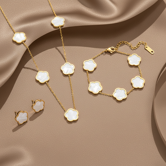 Parure comprenant bracelet, collier et boucles en acier inoxydable 316L doré ornés de petites fleurs en nacre blanche.