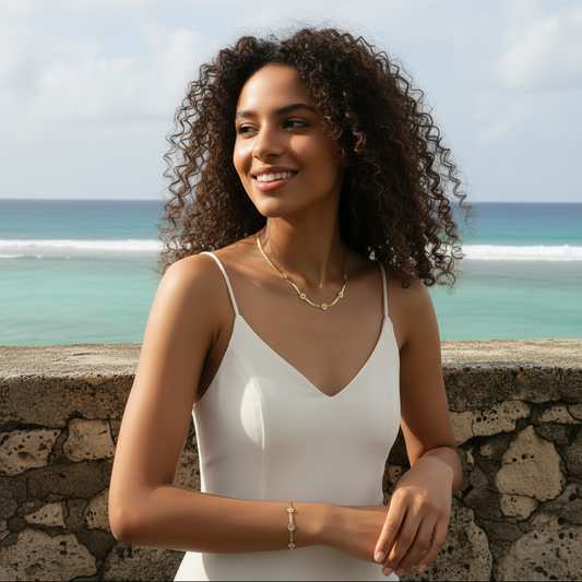 Femme portant une parure collier et bracelet doré en acier inoxydable à maille serpent large de 3 mm orné de 5 petites fleurs.