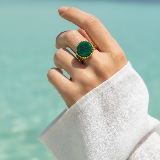 Bague dorée en acier inoxydable 316L avec pierre naturelle Jade africain su une main de femme.