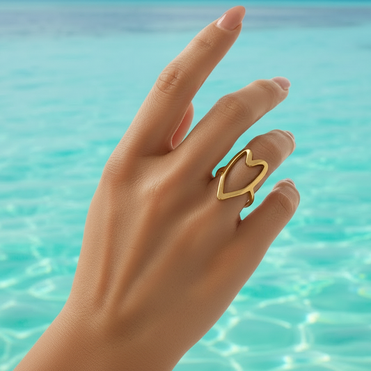 Bague coeur ajouré en acier inoxydable 316L doré portée sur une main de femme.