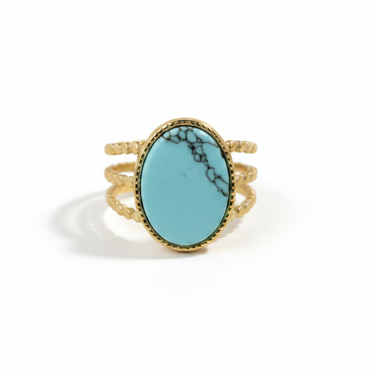 Bague dorée en acier inoxydable ornée d'une pierre naturelle turquoise ovale de face.