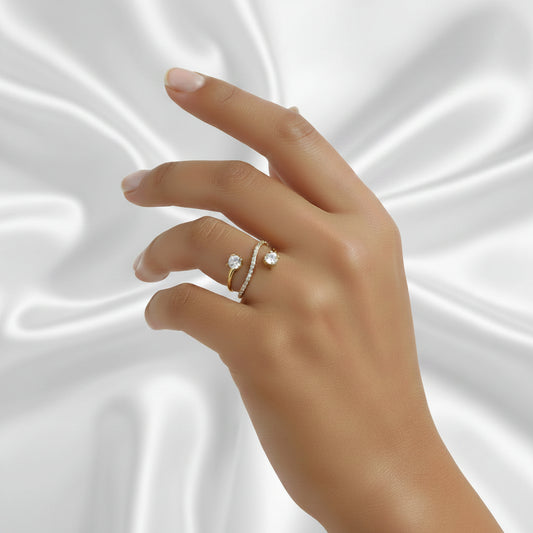Main de femme portant une bague anneau dorée en acier inoxydable 316L avec zircons blancs.