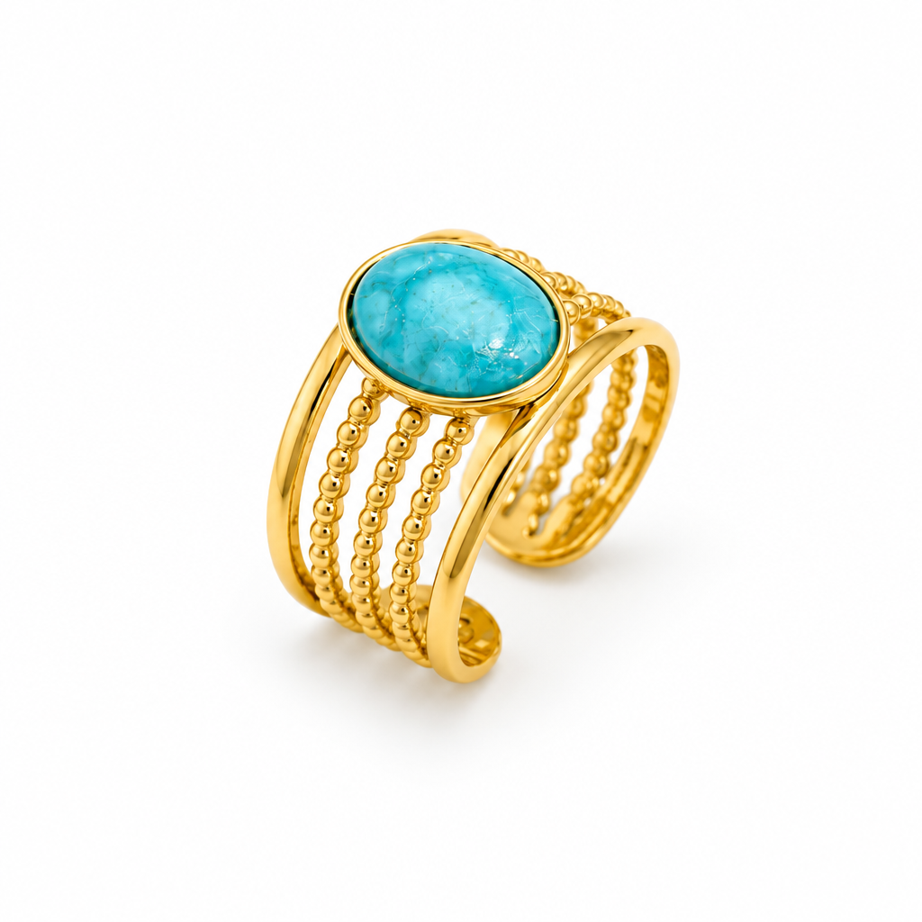 Bagues dorée en acier inoxydable et pierre naturelle turquoise portée sur une main de femme.