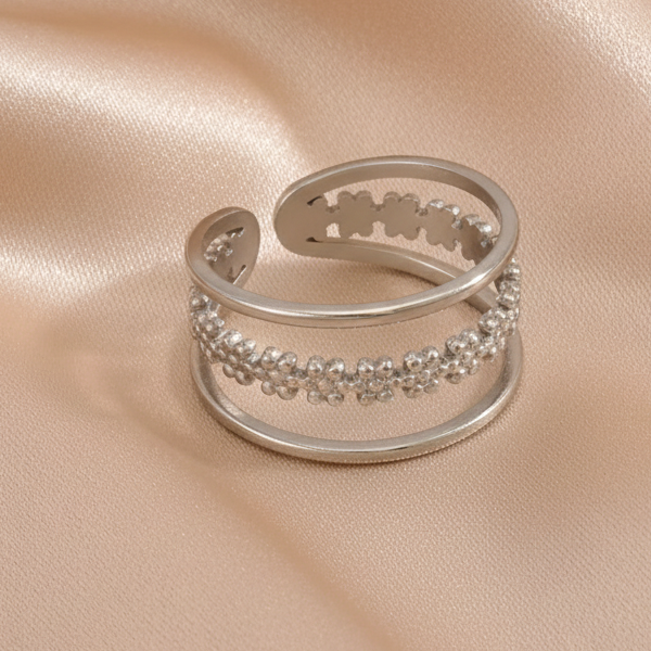 Bague bandeau ajustable en acier inoxydable argenté, ornée d'une couronne de fleurs.