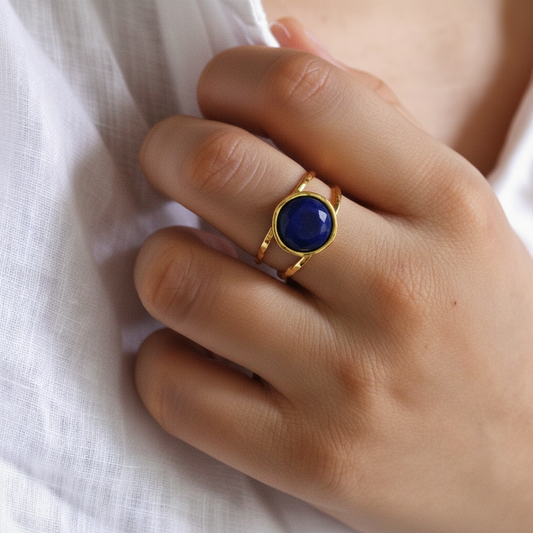 Bague dorée en acier inoxydable ornée d’une pierre naturelle lapis-lazuli sur une main de femme.