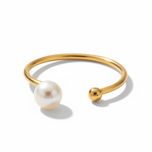 Gros plan sur une bague dorée en acier inoxydable ornée d'une perle d'eau douce naturelle.