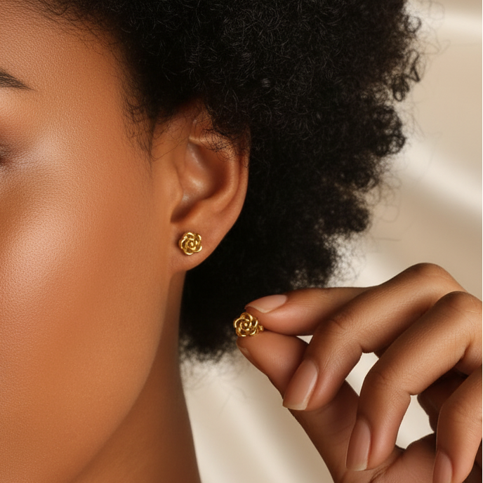 Boucles d'oreilles fleur en acier inoxydable doré portées par une femme, puce 8 mm.