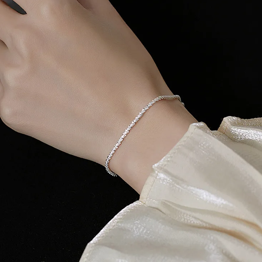 Femme portant un bracelet argenté, brillant, en acier inoxydable maille corde fine, style élégant