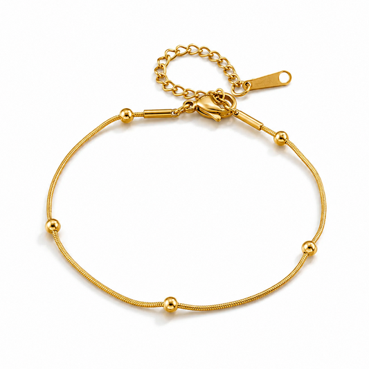 Bracelet doré en acier inoxydable 316L à fine maille serpent orné de perles.