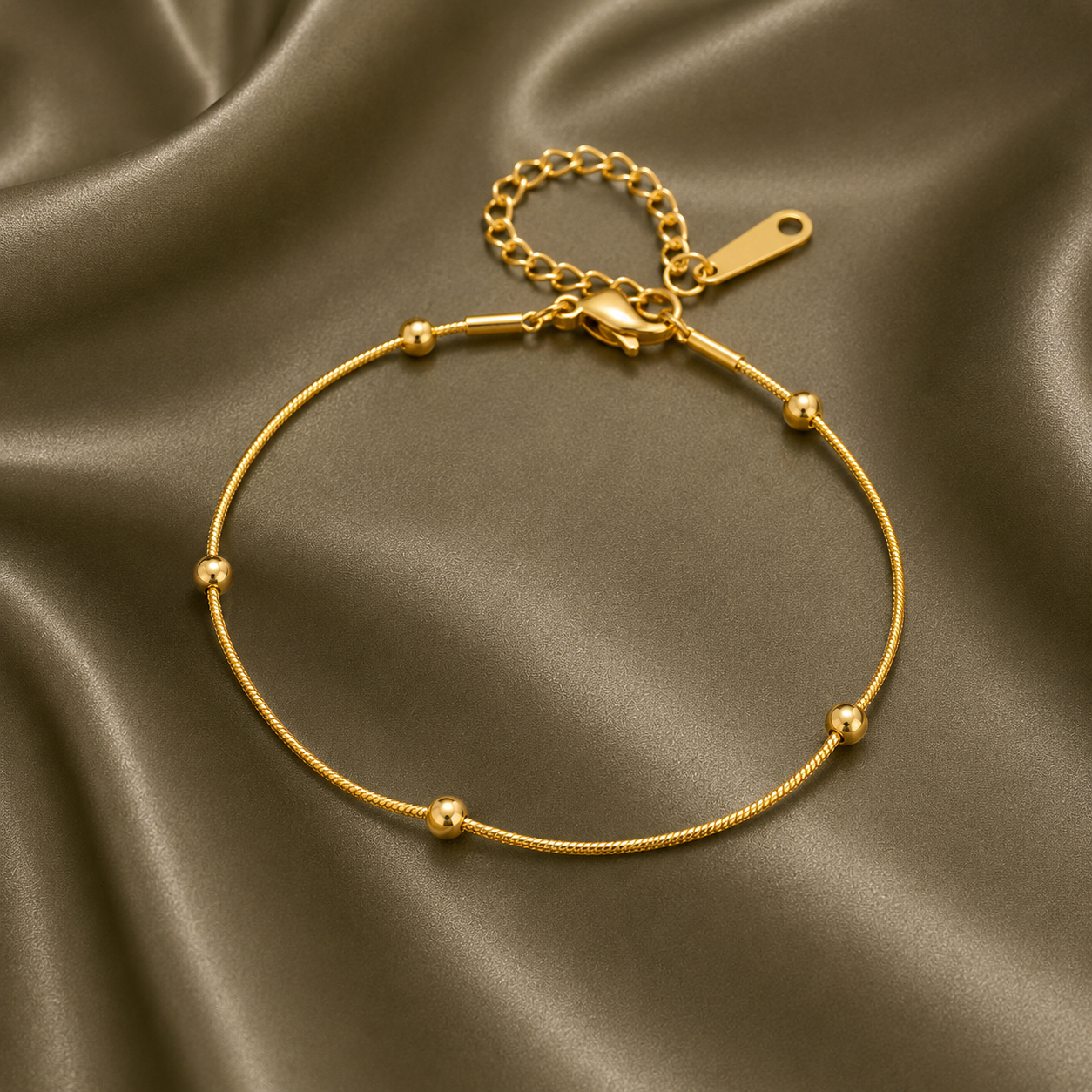 Bracelet doré en acier inoxydable 316L à fine maille serpent orné de perles.