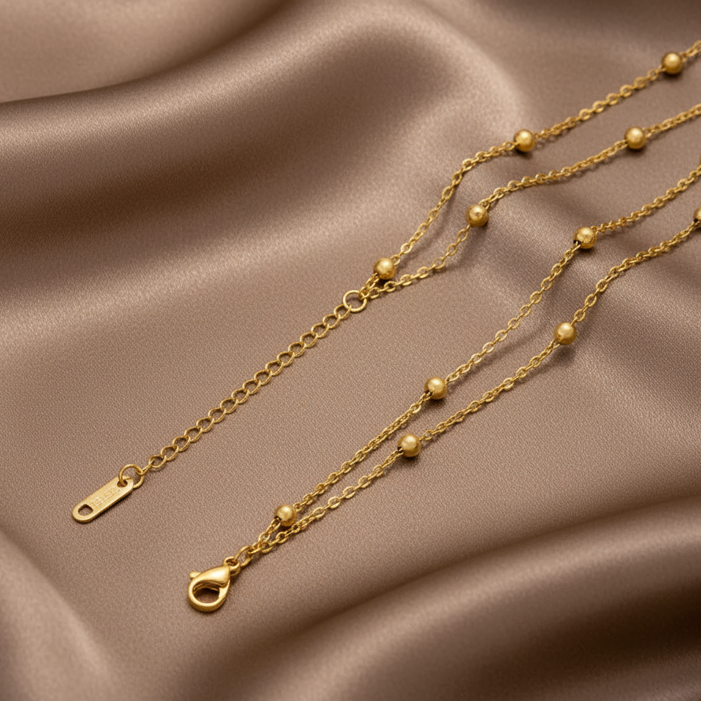 Gros plan sur un bracelet doré en acier inoxydable 316L à double chaîne maille cubaine orné de perles de 3 mm.