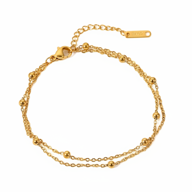 Bracelet doré en acier inoxydable 316L à double chaîne maille cubaine orné de 9 perles de 3 mm.