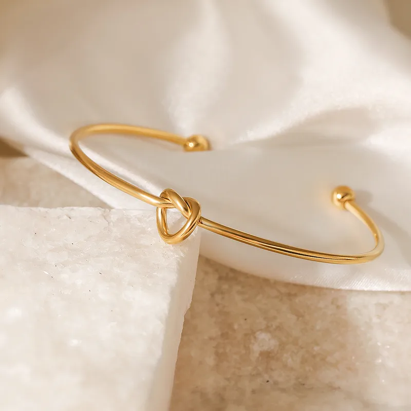 Bracelet manchette fin en acier inoxydable, orné d’un cœur noué.