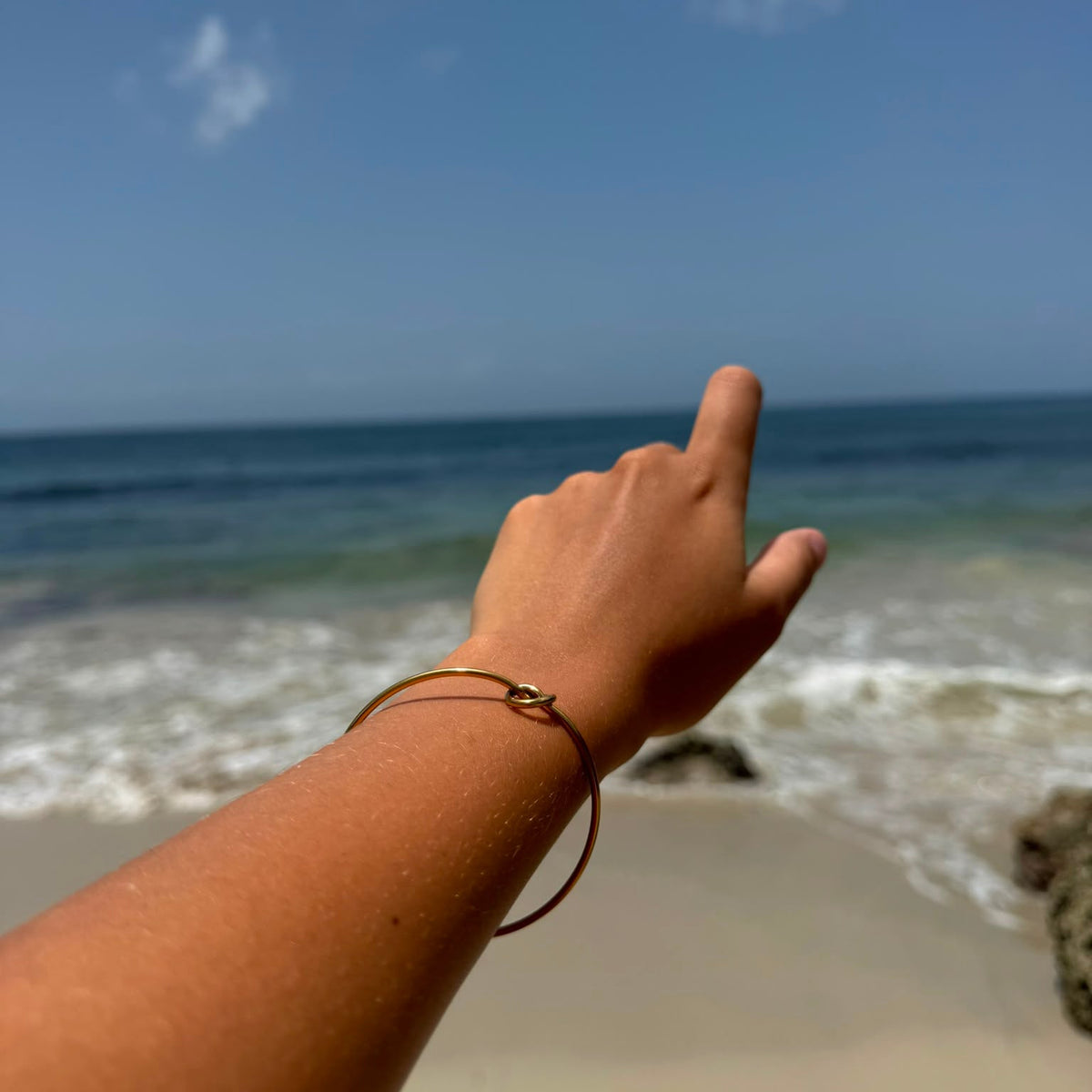 Bracelet manchette fin en acier inoxydable, orné d’un cœur noué porté.