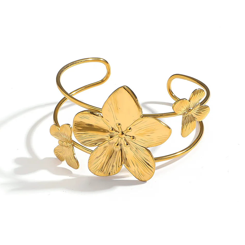 Bracelet manchette en acier inoxydable 316L doré, décoré d’une grande fleur tropicale et de deux papillons.