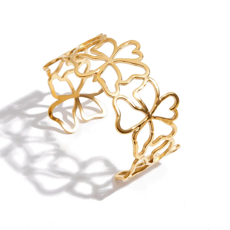 Bracelet manchette large doré en acier inoxydable 316L avec fleurs ajourées.