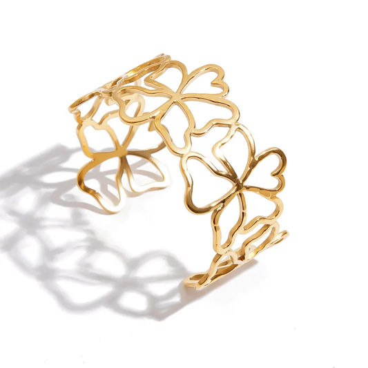 Bracelet manchette large doré en acier inoxydable 316L avec fleurs ajourées.
