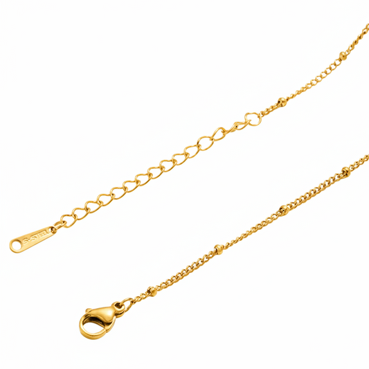 Bracelet chaîne gourmette fine avec perles dorées en acier inoxydable 316L.