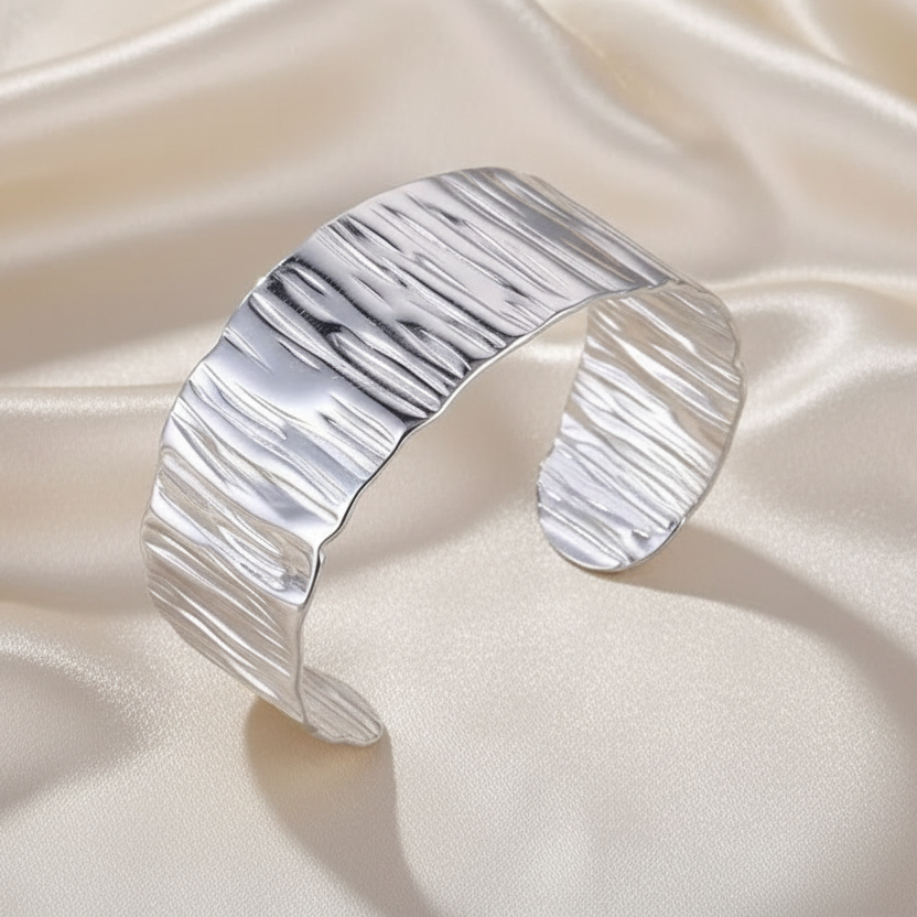 Bracelet manchette large de 3 cm en acier inoxydable 316L argenté, finition martelée et brillante.