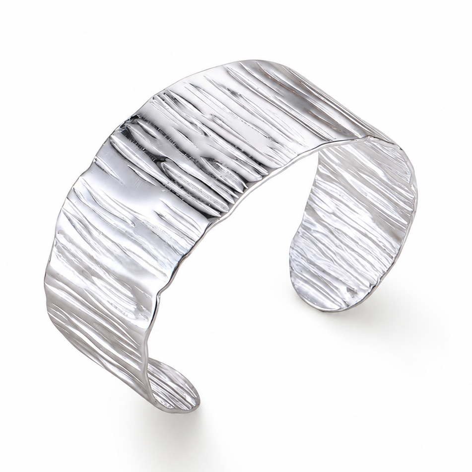 Bracelet manchette large de 3 cm en acier inoxydable poli argenté, finition martelée et brillante.