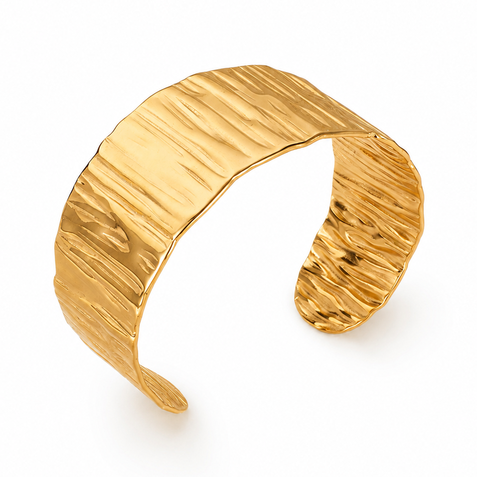 Bracelet manchette large de 3 cm en acier inoxydable poli doré, finition martelée et brillante.