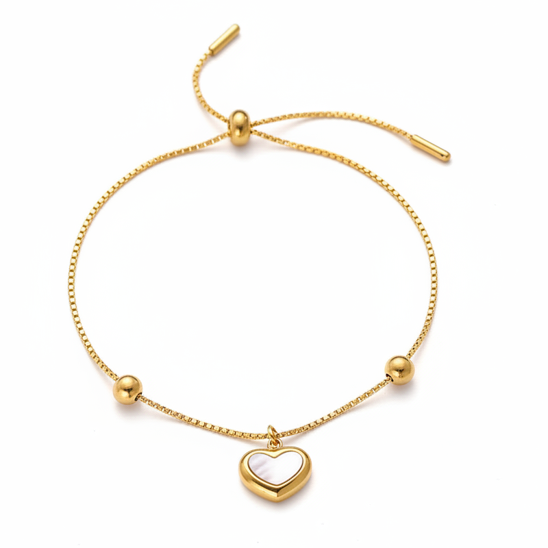 Bracelet fin doré en acier inoxydable 316L avec fermeture coulissante et pendentif cœur en nacre.