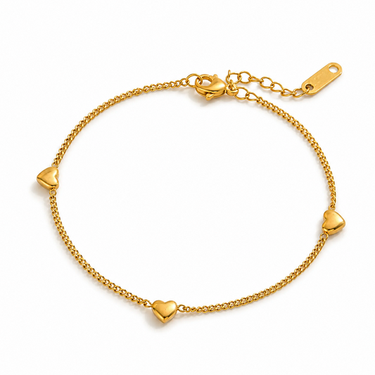 Bracelet doré en acier inoxydable 316L à fine maille gourmette orné de trois petits cœurs.