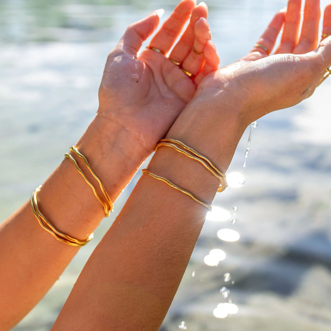 Femme portant un bracelet jonc fin ondulé en acier inoxydable doré