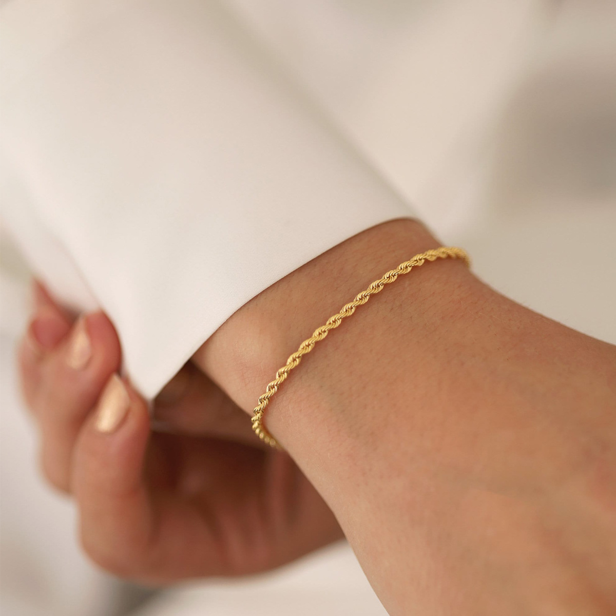 Bracelet doré en acier inoxydable 316L à fine maille corde 2 mm porté sur un poignet de femme.