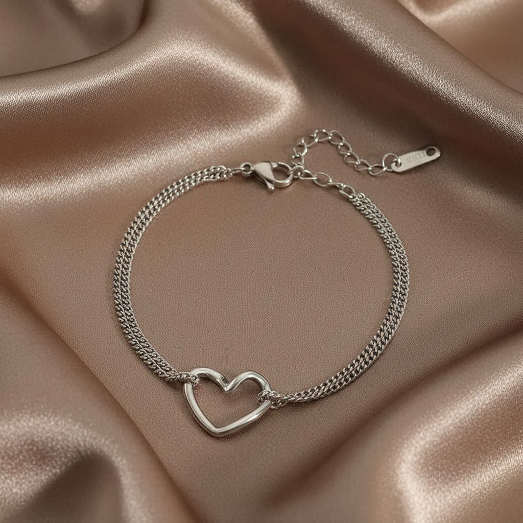 Bracelet en acier inoxydable 316L argenté à double chaîne fine maille gourmette orné d'un coeur ajouré.