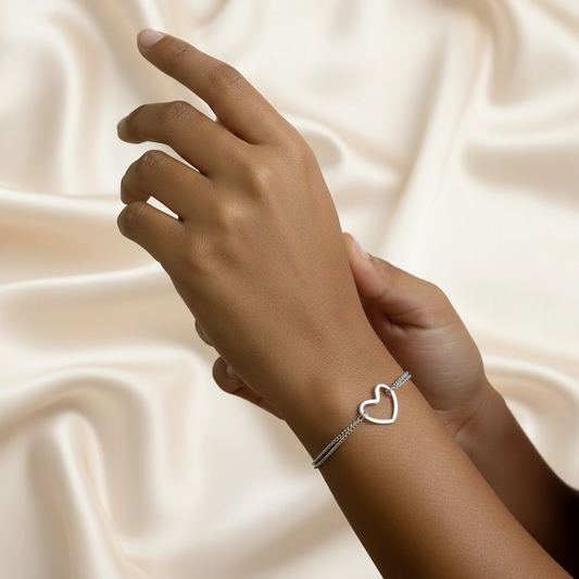 Bracelet argenté en acier inoxydable 316L à double chaîne fine maille gourmette orné d'un coeur ajouré porté sur un poignet
