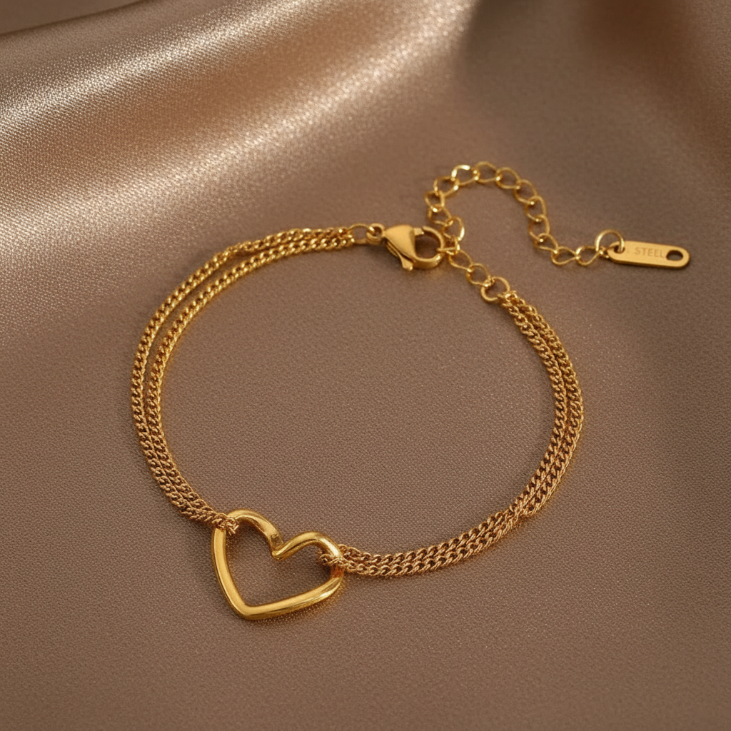 Bracelet en acier inoxydable 316L doré à double chaîne fine maille gourmette orné d'un coeur ajouré.