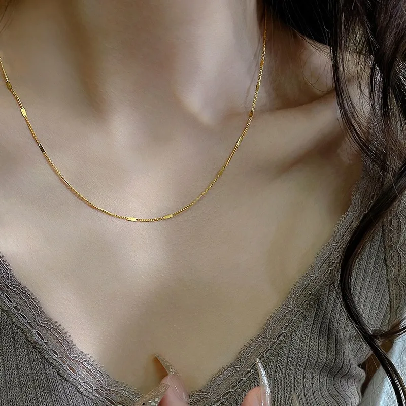 Femme portant un collier doré en acier inoxydable, fine maille gourmette alternée mailles plates