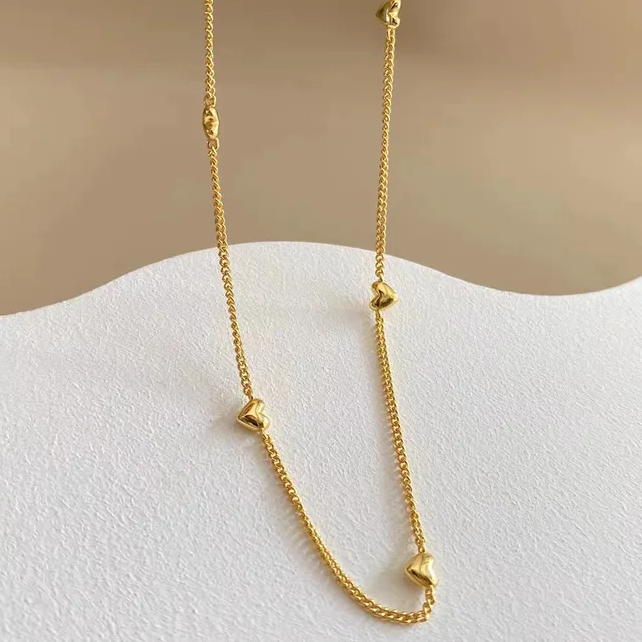 Collier doré en acier inoxydable maille gourmette fine avec neuf petits cœurs dorés