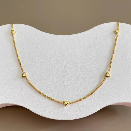 Collier doré en acier inoxydable maille gourmette fine avec neuf petits cœurs dorés