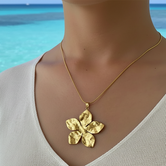 Femme portant un collier doré en acier inoxydable, maille serpent, pendentif fleur tropicale martelée, bijou bohème