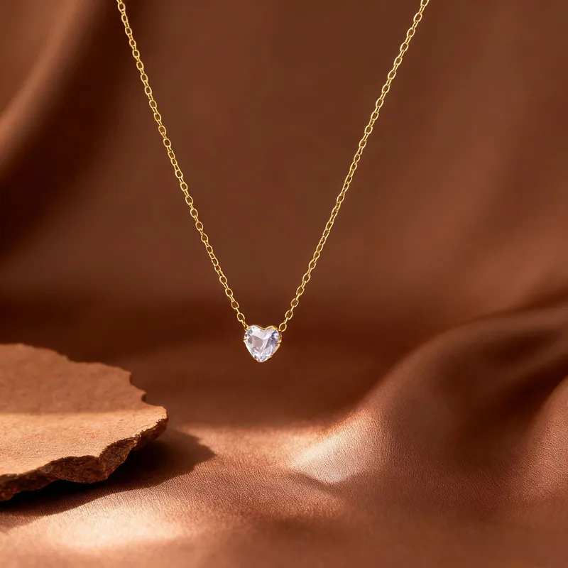 Collier doré en acier inoxydable 316L avec pendentif petit coeur en strass blanc et chaîne fine maille forçat.