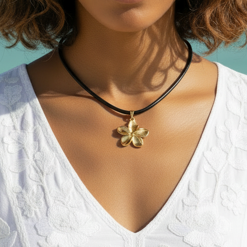 Femme portant un collier avec pendentif fleur dorée en acier inoxydable et cordon en cuir noir.