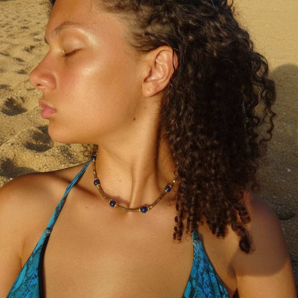 Collier doré en acier inoxydable 316L avec pierres naturelles lapis-lazuli porté sur un buste de femme.