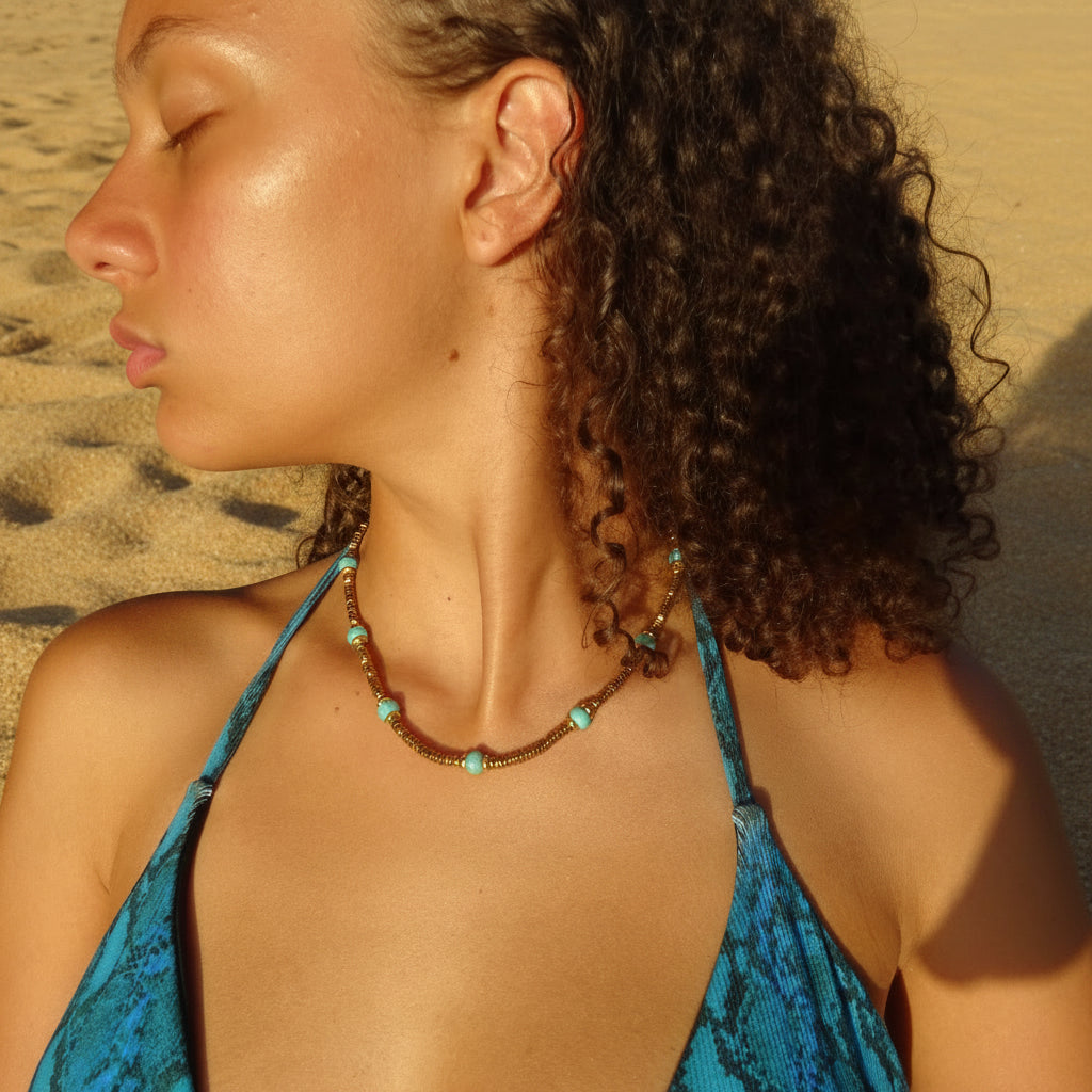Collier doré en acier inoxydable 316L avec pierres naturelles turquoise porté sur un buste de femme.