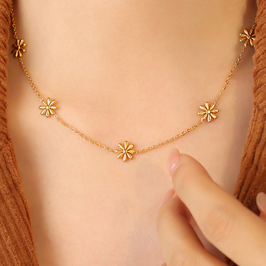 Femme portant un collier doré en acier inoxydable avec 5 petites fleurs, bijou bohème