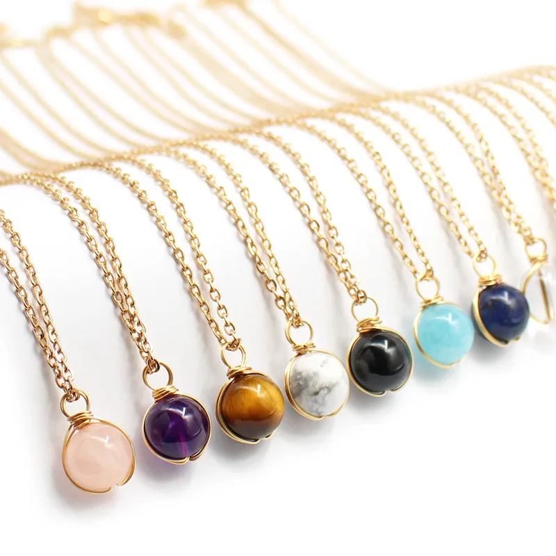 Collier doré en acier inoxydable à chaîne fine maille forçat et pendentif boule en pierre naturelle.