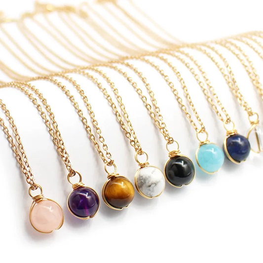 Collier doré en acier inoxydable à chaîne fine maille forçat et pendentif boule en pierre naturelle.