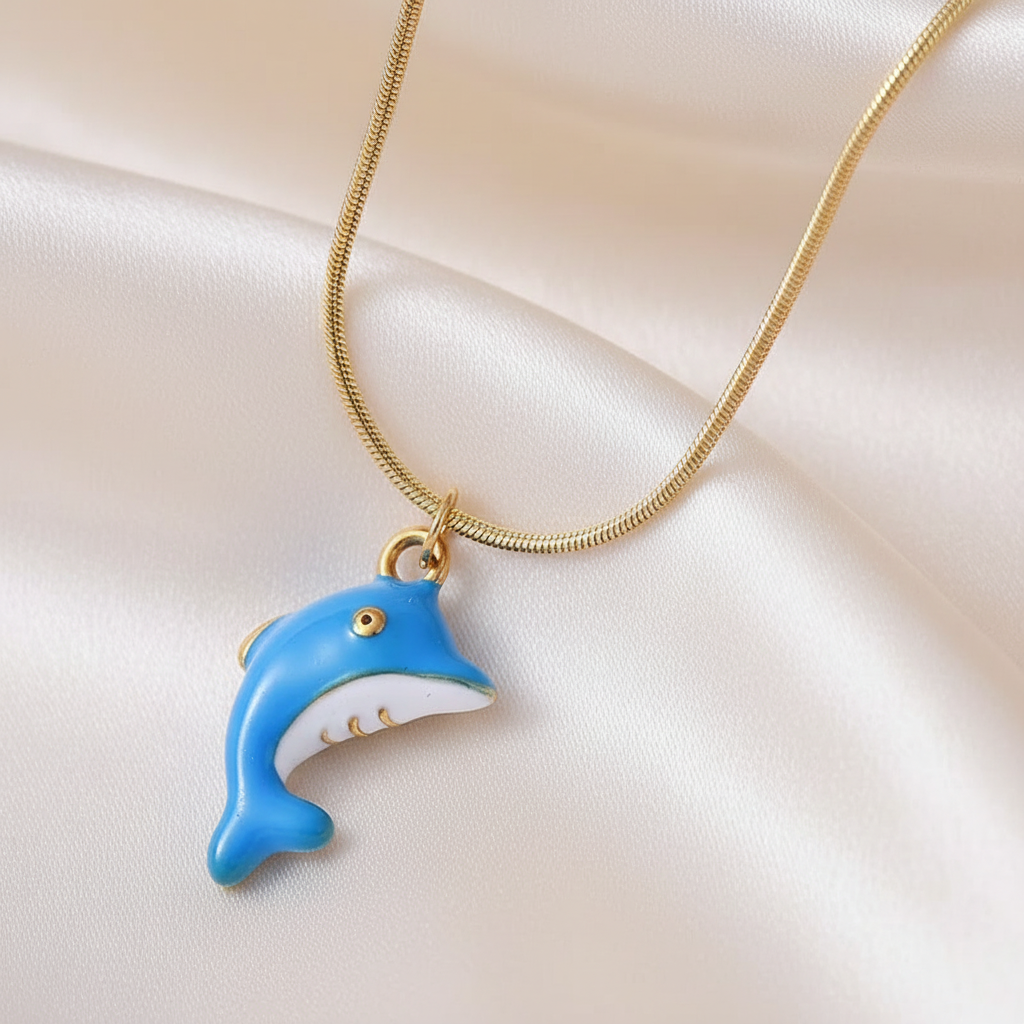 Zoom sur un collier enfant en acier 316L doré orné d'un pendentif dauphin émaillé bleu